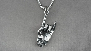 Close-up of retro punk rock skeleton hand pendant made of titanium steel on square pearl chain