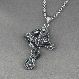 Gothic silver dragon cross necklace with skull pendant on grey textured background