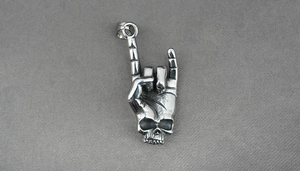 Detailed view of rock sign gesture pendant with skull element in retro steel finish