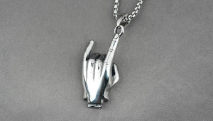 Macro shot of silver rock gesture pendant on box chain, crafted from durable titanium steel
