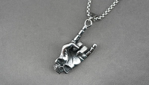 Detail of vintage silver titanium steel necklace featuring a rock skull hand gesture pendant