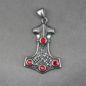 Silver Viking Mjölnir hammer pendant with Celtic knots and red crystals on grey fabric