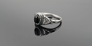 Macro view of vintage titanium steel ring with oval black stone and retro hollow detailing