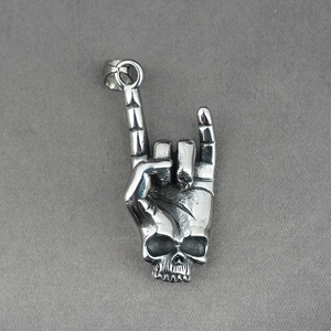 Punk rock skull hand gesture pendant in vintage stainless steel finish on dark textile
