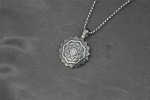 Dettaglio del ciondolo loto mandala e simbolo Om su una catena a scatola in argento antico