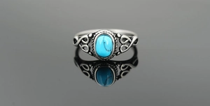 Macro detail of vintage silver ring with oval turquoise gemstone and intricate carvings