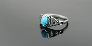 Macro shot of vintage titanium steel ring with an oval turquoise stone and filigree detail