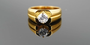 Vue détaillée d'une bague en titane doré poli avec un zircon rond serti à quatre griffes