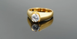 Polished gold titanium ring featuring a single round brilliant-cut zircon inlay detail