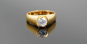 Macro shot of a classic gold titanium men's ring with a large sparkling solitaire diamond