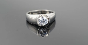 Macro shot of polished titanium steel ring with round zircon in a sleek half-bezel setting