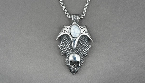Gothic punk necklace showing metal bat wings with skull detail and white turquoise stone