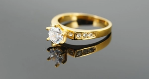 Macro shot of gold-plated six-prong titanium steel ring with a large cubic zirconia stone