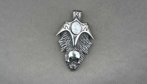 Close-up of gothic stainless steel necklace with turquoise inlay and skull pendant design