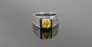 Vue rapprochée d'une bague pour homme en acier avec une pierre jaune et des détails gravés