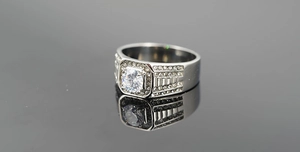 Vue macro d'une alliance pour hommes en titane avec diamant rond et accents pavés sur le côté