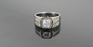 Détail d'une bague en acier titane avec diamant central rond et sertissage en halo