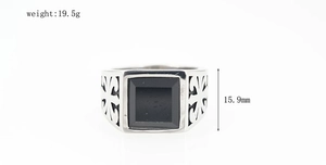 Detailed view of vintage steel ring with black stone inlay and fleur-de-lis carving