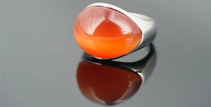 Vista macro dettagliata di una grande pietra preziosa arancione su anello in argento
