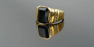Dettaglio anello da uomo in oro con onice nero e motivi a greca sulle fasce