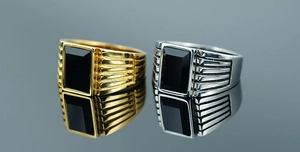 Dettaglio di anelli vintage da uomo in acciaio inossidabile oro e argento con pietra nera