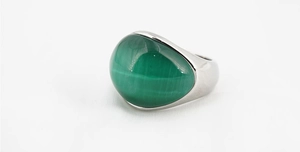 Macro di un anello in titanio argento con una gemma di malachite ovale verde lucidata