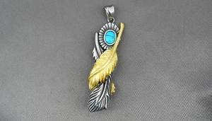 Detailed shot of double feather pendant with turquoise stone in vintage titanium steel