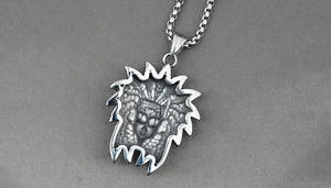 Détail du pendentif masque tribal maya en acier argenté avec une chaîne à boîte