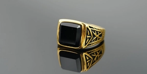 Macro d'une bague vintage en or pour homme avec pierre d'obsidienne noire carrée et gravures