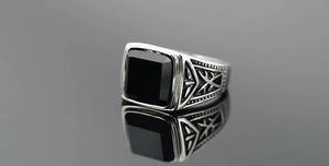 Macro d'une bague rétro pour homme en acier avec pierre d'obsidienne noire et gravures
