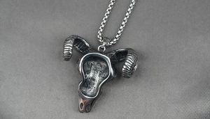 Detailed view of silver ox skull pendant with spiral horns and round box chain necklace