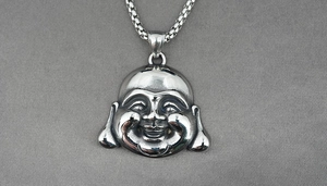 Detalle macro del colgante de Buda sonriente plateado con cadena de perlas cuadradas