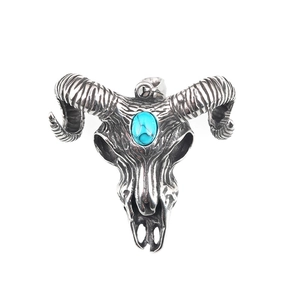 Vintage silver bull head pendant with turquoise stone inlay on minimalist white backdrop