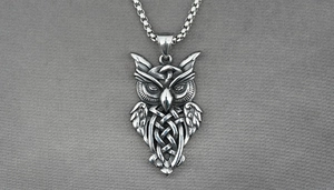 Close-up of vintage silver owl pendant with Celtic knot details on a stainless steel chain