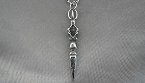 Detailed view of stainless steel Phurba pendant with intricate religious engravings