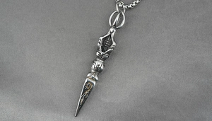 Macro shot of vintage titanium steel Phurba pendant with detailed religious carvings