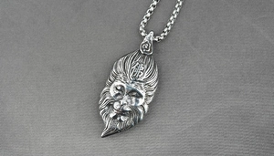 Detail of vintage silver Buddha pendant with intricate facial carving on a round box chain