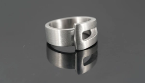 Gros plan sur la bague en acier titane de style industriel avec boucle géométrique