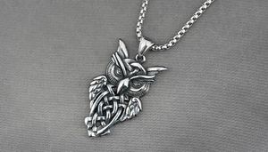 Detailed macro view of vintage owl pendant with intricate Celtic knot patterns on box chain