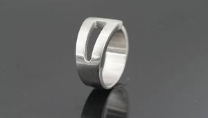 Vue macro d'une bague en acier titane argent mat avec ouverture rectangulaire évidée