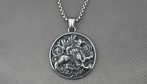 Macro detail of silver round medallion with engraved griffin on a vintage box chain