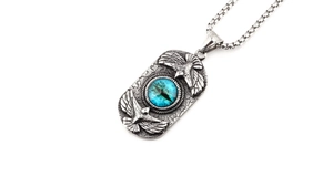 Detailed view of retro steel eagle pendant with blue eye stone and textured rectangle plate