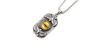 Close-up of vintage double eagle pendant with yellow evil eye on cracked steel texture