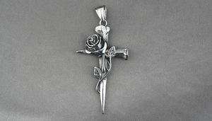 Dettaglio della collana a croce gotica in acciaio con rosa e finitura anticata