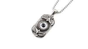 Detail of vintage double eagle pendant with blue devil eye in silver titanium steel