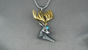 Detailed close-up of stag head necklace with turquoise eye and golden antlers