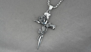 Dettaglio del ciondolo a croce argento retrò con rosa realistica su collana a catena box