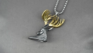 Detailed 45-degree angle of a vintage stag head pendant with gold antlers and silver base
