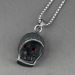 Gothic skull pendant necklace with red eye gemstones and embossed floral details