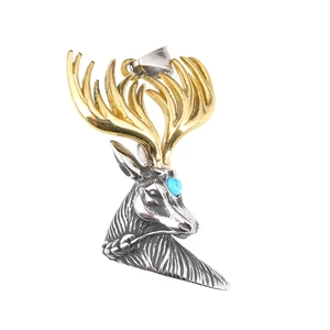 Vintage buck head necklace with gold antlers and turquoise stone on white background